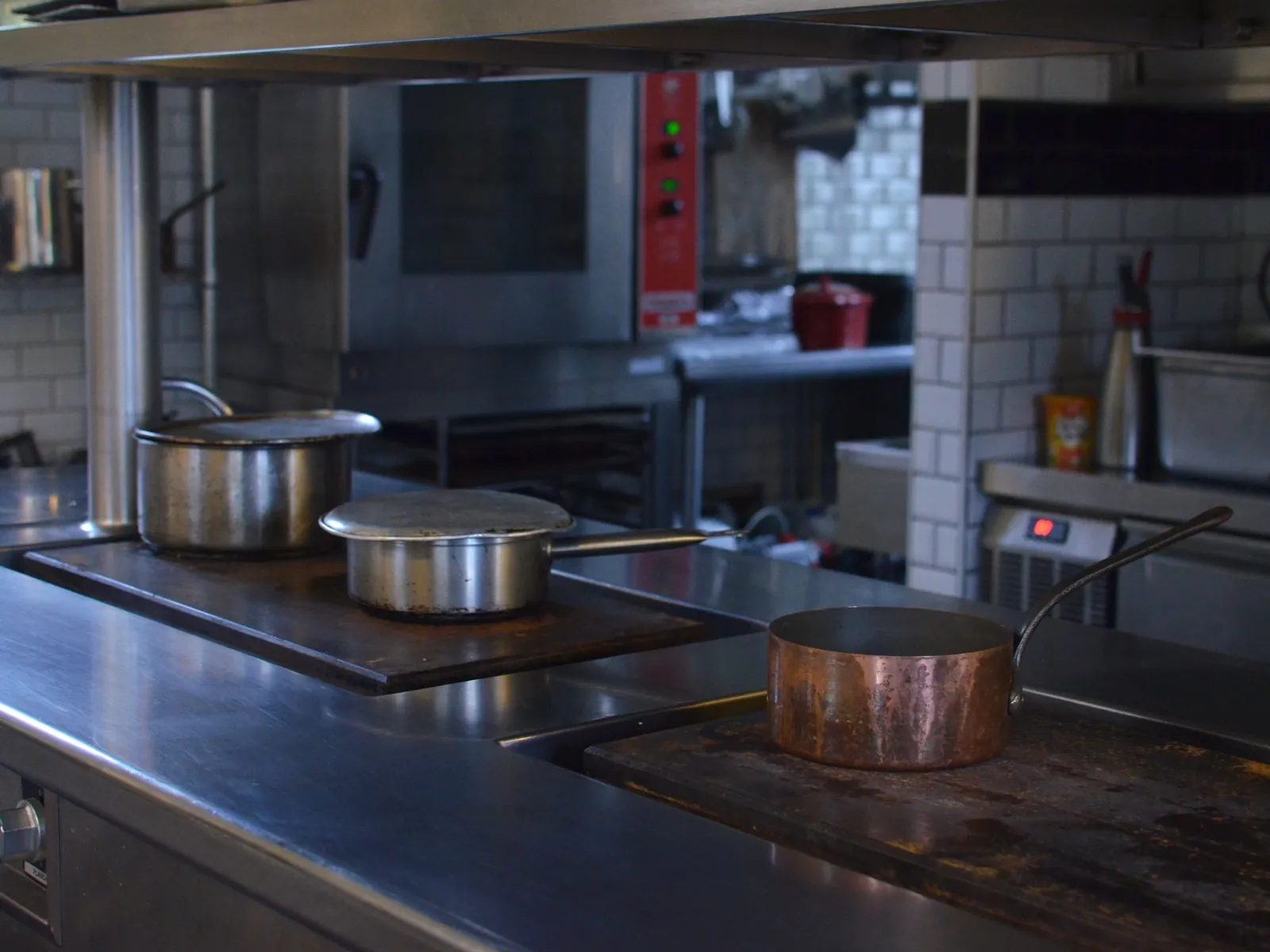 Plan de cuisson central en inox brossé, casseroles en service
