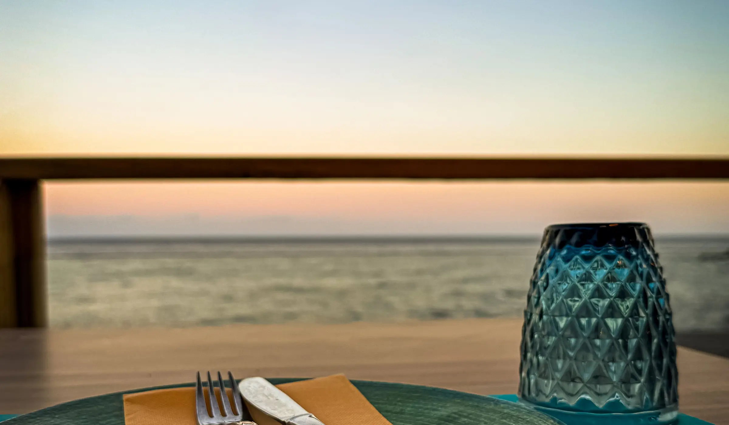 Une table dressée face à la mer, à la tombée du jour